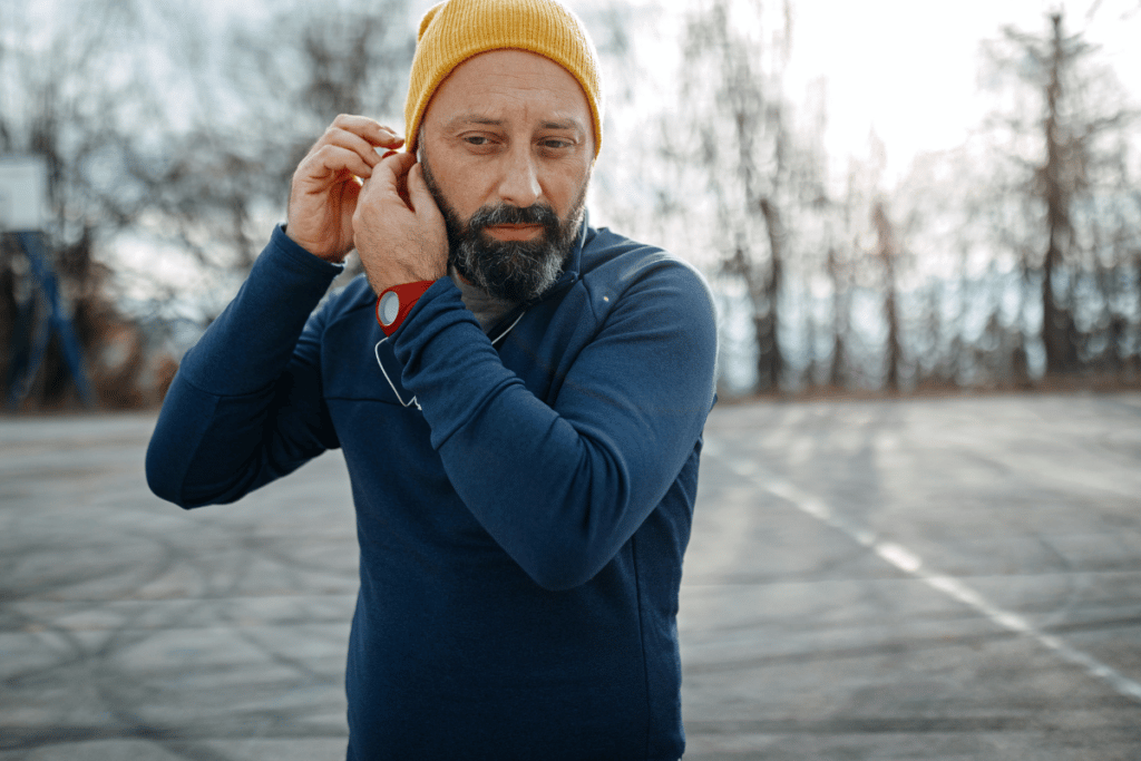 man adjusting his earbuds before starting a run