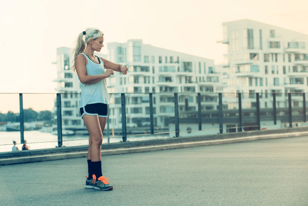 woman checking her fitness tracking during a run