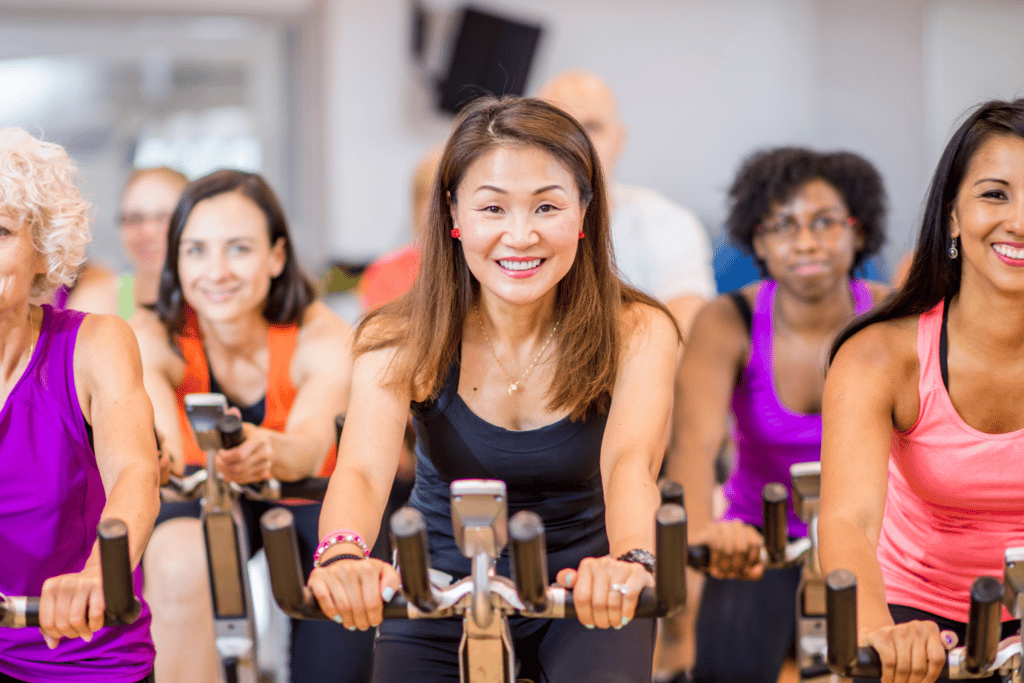 group of women riding stationary bikes